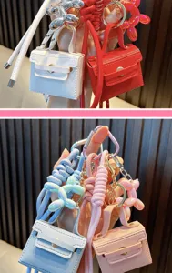 Close-up view of mini PU bag keychains with colorful balloon dog charms for women.