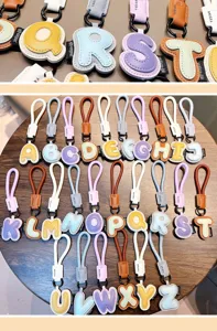 Detailed view of the colorful leather 26 English alphabet keychain collection on wood.