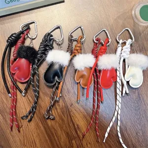 Portachiavi guantini in pelle con polsini in peluche e cordini intrecciati per borse.