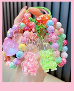 Detail van schattige kralen konijnen sleutelhanger met roze en groene bedels