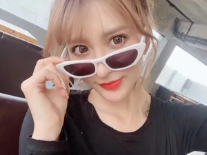 Modella che indossa eleganti occhiali da sole cat-eye bianchi con strass in primo piano