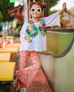 Detailed lifestyle shot of a girl wearing white sunflower shaped sunglasses outdoors