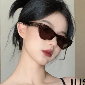Close-up of woman wearing stylish tortoiseshell cat-eye sunglasses with brown tinted lenses