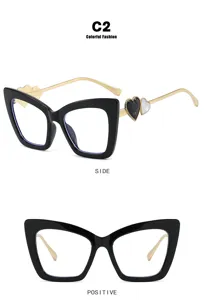 Detailed view of fashion cat-eye glasses with heart accents and gold metal arms.