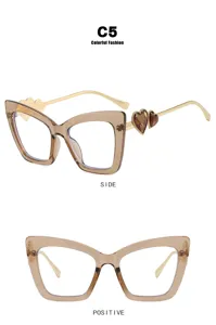 Detail view of champagne cat-eye glasses frame with heart decor and gold temples.