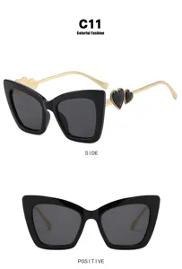 Detailed macro view of fashionable cat-eye glasses with heart accents on gold temples.