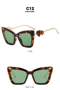 Detail of tortoiseshell cat-eye glasses with heart temples and green lenses
