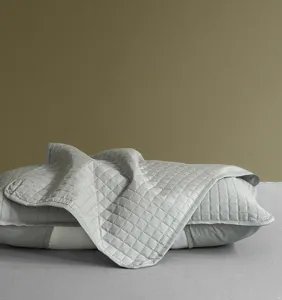 Close-up of gray quilted pillowcase protector showing diamond stitching texture