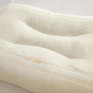 Close-up of butterfly latex pillow with exquisite embroidery and silk latex text.