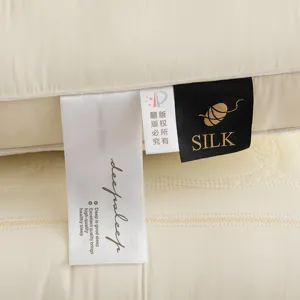 Close-up view of the material tags and delicate embroidery on a high-quality cream latex pillow