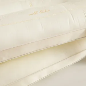 Detailed view of cream Tencel latex pillow featuring elegant gold silk latex embroidery