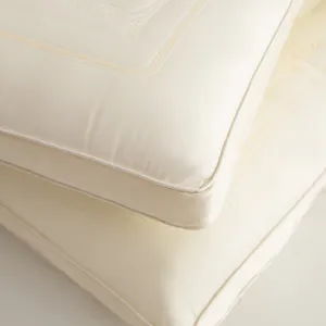 Close-up of premium Tencel latex pillow with elegant 3D embroidery and piping detail.
