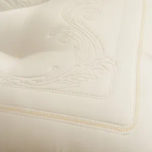 Close-up detail of the elegant embroidery and quilted texture on a cream Tencel latex pillow