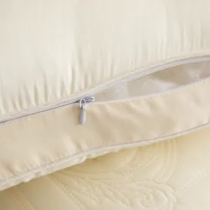 Detail view of the invisible zipper and white filling on a soft cream Tencel latex pillow.