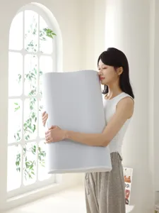 Modelo abrazando una gran almohada ergonómica de espuma viscoelástica para el cuello