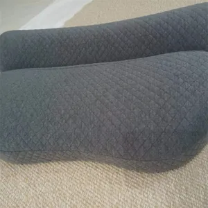 Primer plano detallado de una almohada de espuma viscoelástica mariposa gris con acolchado.