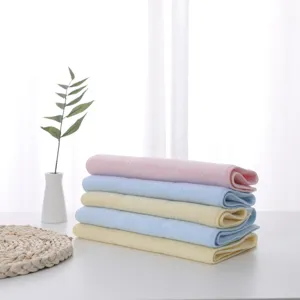 Stacked colorful latex square towels in soft pink, blue, and yellow hues.