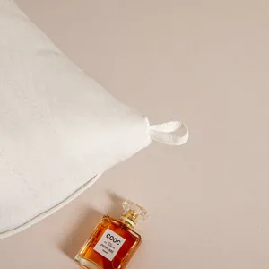 Vista macro detallada de la esquina de la funda de almohada blanca con lazo para colgar