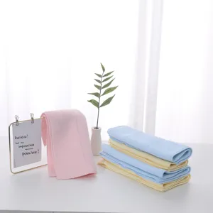 Soft pastel latex face towels folded and displayed in a minimalist bright home setting