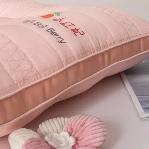 Detail shot of a pink quilted neck protection pillow featuring Goji Berry embroidery