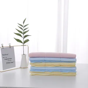 Close-up stack of soft latex face towels in pastel pink blue and yellow for daily use