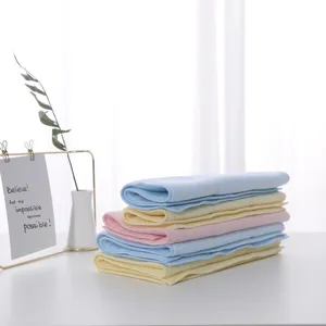 Macro detail of soft stacked latex square towels in pastel blue, pink and yellow
