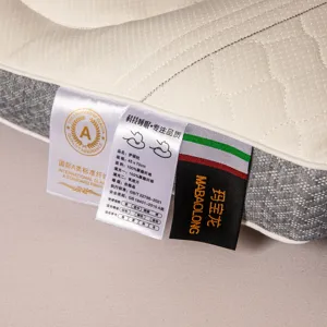 Close-up detail of cervical pillow tags showing 45x70cm dimensions and material quality