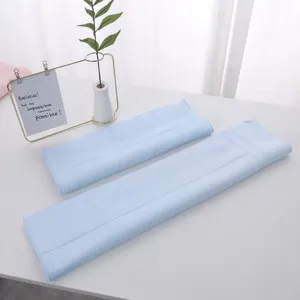 Detail of soft light blue latex face towels on a minimalist white table setting