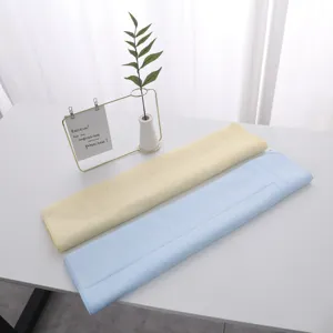 Macro detail of soft yellow and blue latex face towels on a minimalist white table