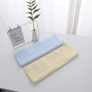 Macro view of soft blue and yellow latex face towels on a minimalist white table
