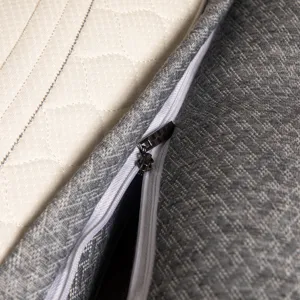 Macro detail of high-quality pillow zipper and textured grey fabric with quilted pattern