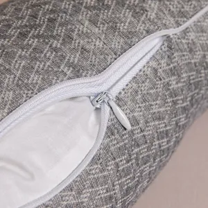 Close-up of hidden zipper on grey textured neck pillow with high quality fabric finish.