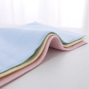 Close-up of soft pastel latex face towels showing fine texture and stitched edges