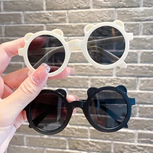 Detailansicht der bärenförmigen Kinder-Sonnenbrille in Creme und Schwarz mit UV-Schutz