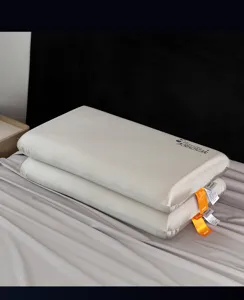 Detalle de dos almohadas de espuma viscoelástica apiladas sobre una sábana gris.