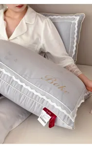 Detailed close-up showing elegant white lace trim and delicate embroidery on a grey pillow