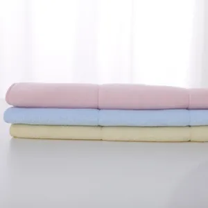 Macro detail of soft pastel latex face towels in pink, light blue, and yellow colors