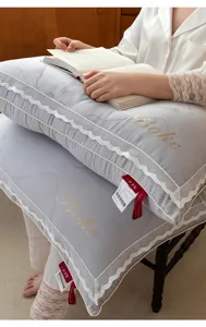 Soft grey pillow with elegant lace edges and decorative gold embroidery details for home