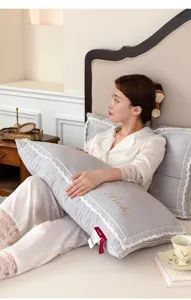 Detailed view of a grey lace pillow with elegant embroidered Boke logo in bed setting