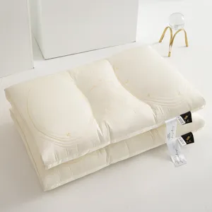 Detail of two stacked Tencel latex pillows with elegant butterfly embroidery and silk tags