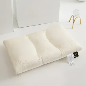 Side view of cream Tencel latex pillow with butterfly embroidery and brand label