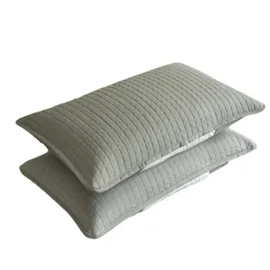 Pair of grey quilted pillowcase protectors with geometric grid stitching pattern