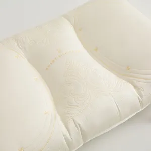 Detail view of cream tencel latex pillow with intricate floral embroidery pattern