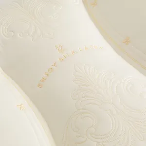 Close-up of elegant floral embroidery on a premium white silk latex cervical pillow