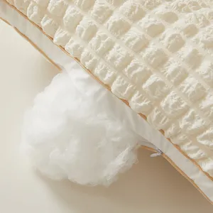 Detalle de almohada de algodón seersucker blanco con cremallera y relleno de fibra
