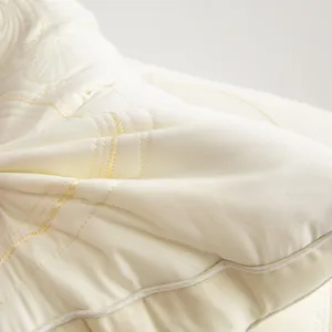 Close-up detail of cream embroidered tencel latex pillow with butterfly pattern