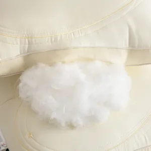Close-up of fluffy white pillow filling on cream Tencel fabric with embroidery