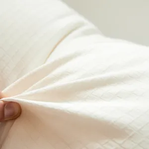 Close-up view of a soft white Japanese raw cotton pillow showing detailed grid fabric texture