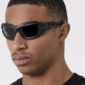 Close-up detail of futuristic black wrap-around sunglasses with irregular punk frame