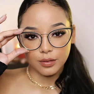 Primer plano de monturas de gafas cat-eye negras y doradas en una elegante modelo